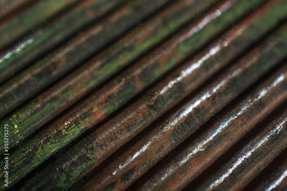 Corrugated diagonal texture with vertical convex lines of brown and green color with blur background Corrugated diagonal texture with vertical convex lines of brown and green color with blur background