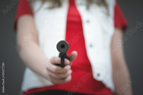 Fotografie Woman with a gun is aiming ahead close up.