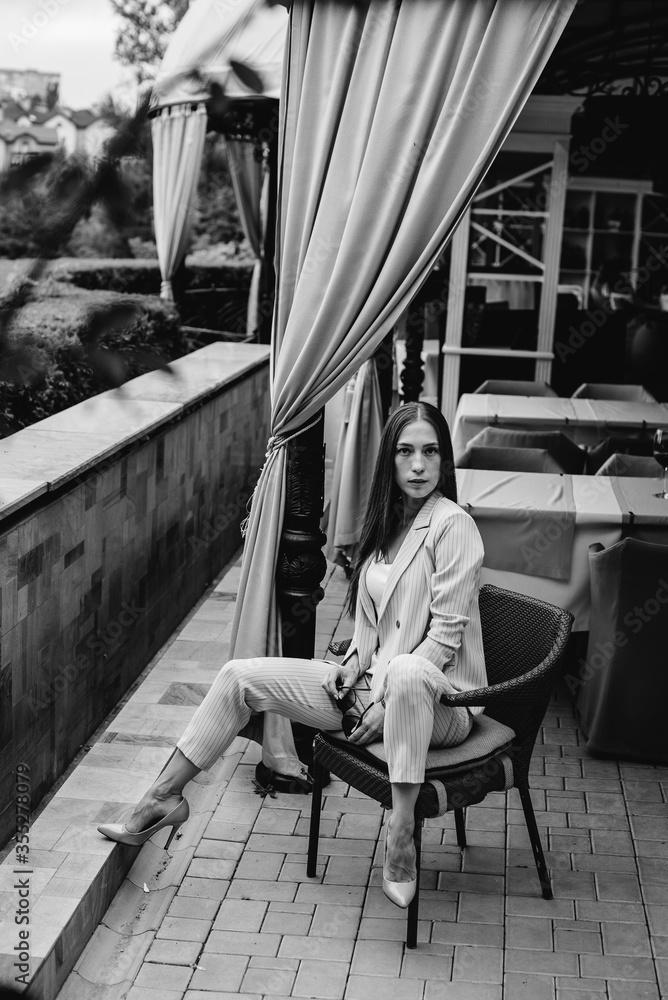 Obraz premium Sexy girl sitting on a beautiful veranda. Black and white.
