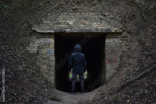 man stand before entrance to old abandoned tunnel in forest © Oleksandr