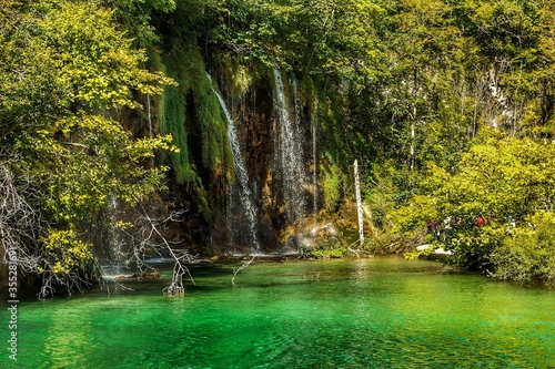 Fotografía Landscape of waterfall and turquoise lake in the forest