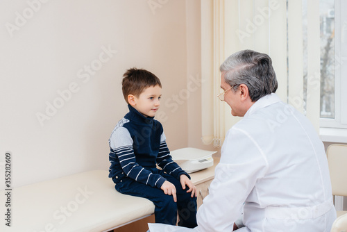 A young boy is listened to and treated by an experienced doctor in a modern clinic. A virus, and an epidemic