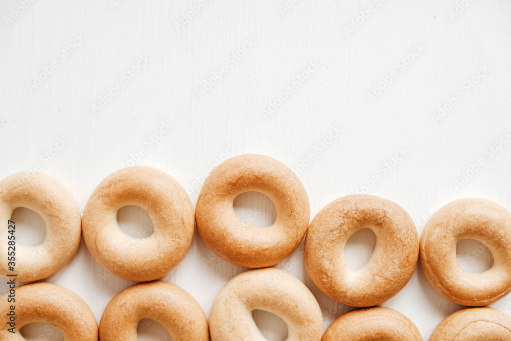 Drying or mini round bagels on a white wooden background. Top view. Copy, empty space for text