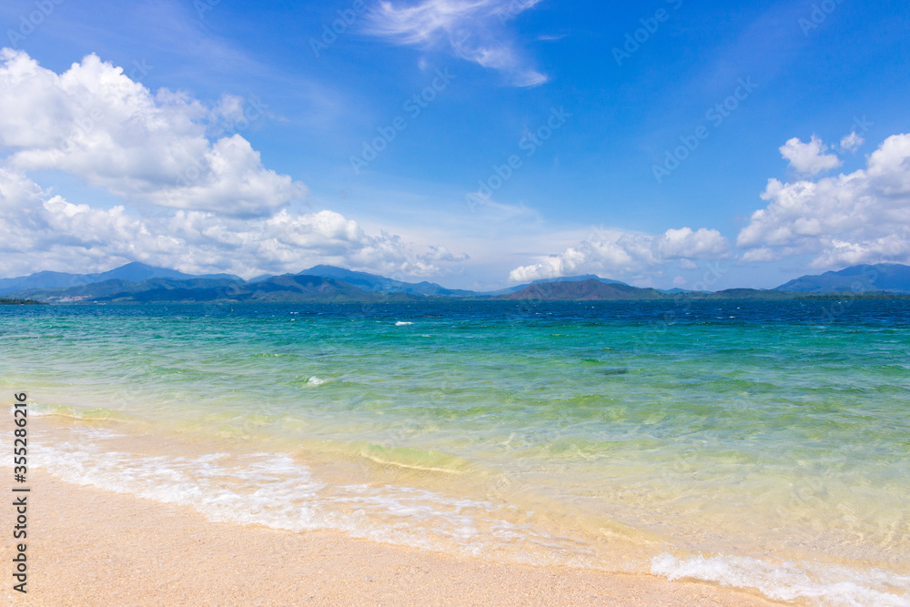 Luxury beach with azure water and cloudy sky. Concept background for tropical travel or summer exotic vacation. Philippine paradise beach.