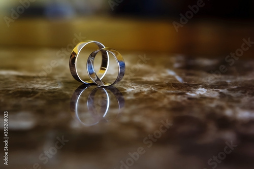 Wedding rings lie on marble. Wedding concept. Wedding minimalism. Gold wedding rings.