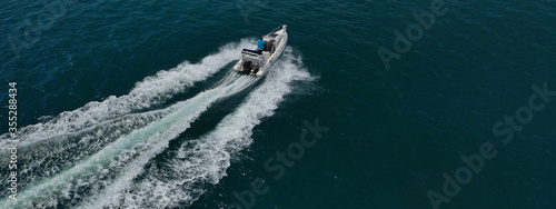 Aerial drone ultra wide photo of inflatable powerboat cruising in high speed near Mediterranean port © aerial-drone