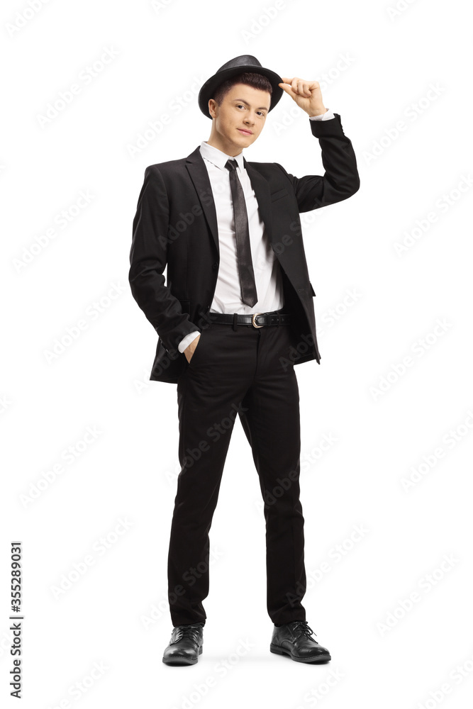 Full length portrait of a guy in a black suit holding his a fedora hat Full length portrait of a guy in a black suit holding his a fedora hat