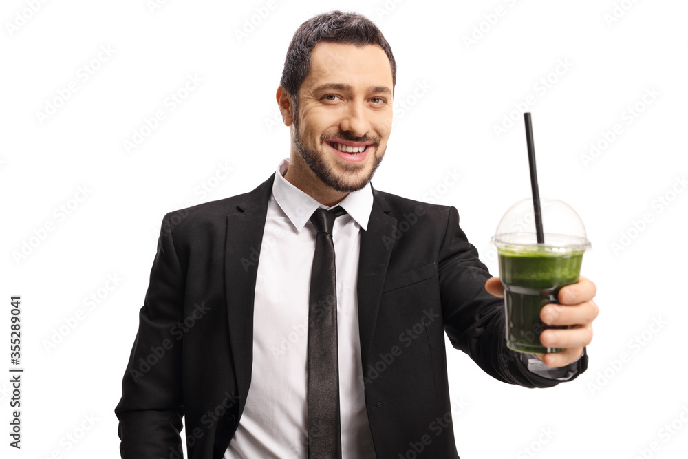 Man in a suit and tie holding a healthy green smoothie in his hand Man in a suit and tie holding a healthy green smoothie in his hand