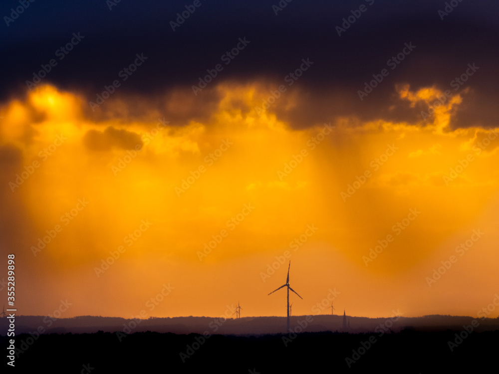 Obraz premium golden sunsten with a view of wind turbines