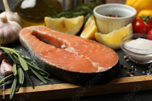 Composition with salmon meat and spices on wooden background, close up