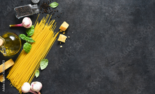Ingredients for making pasta. Raw spaghetti with on a black background. View from above.