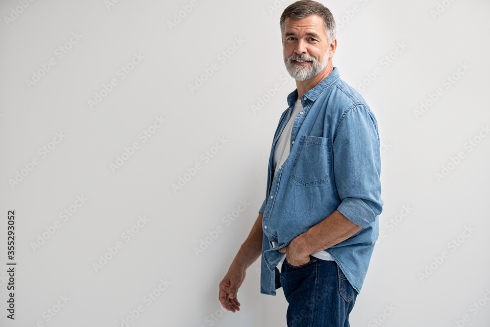 Fototapeta premium Portrait of smiling mature man standing on white background.