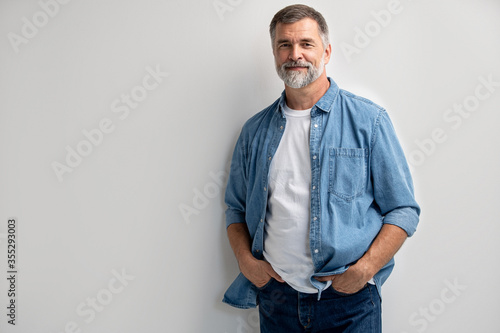 Portrait of smiling mature man standing on white background. photo