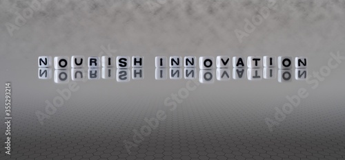 nourish innovation concept represented by black and white letter cubes on a grey horizon background stretching to infinity