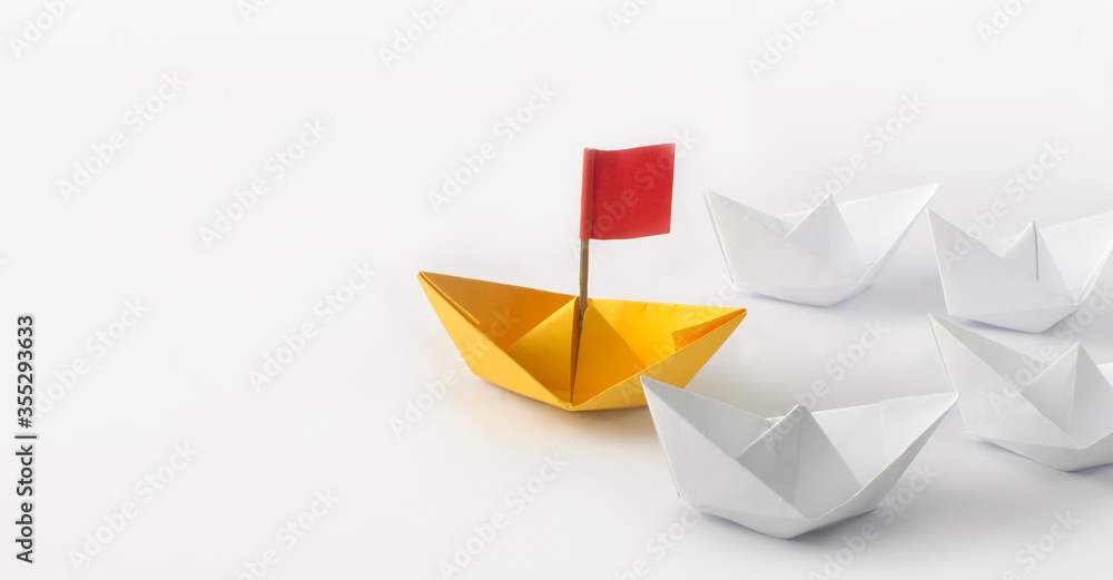 Leadership concept. Red flag Origami Yellow Paper boat (ship) leading the other white boats. One leadership leads other ships.
Leadership concept. Red flag Origami Yellow Paper boat (ship) leading the other white boats. One leadership leads other ships.
