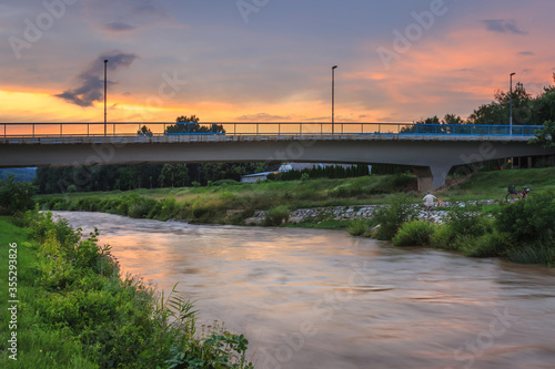 Beautiful sunset over Gazela bridge in Pirot, Nisava river and a man with a dog on a riverbank photo