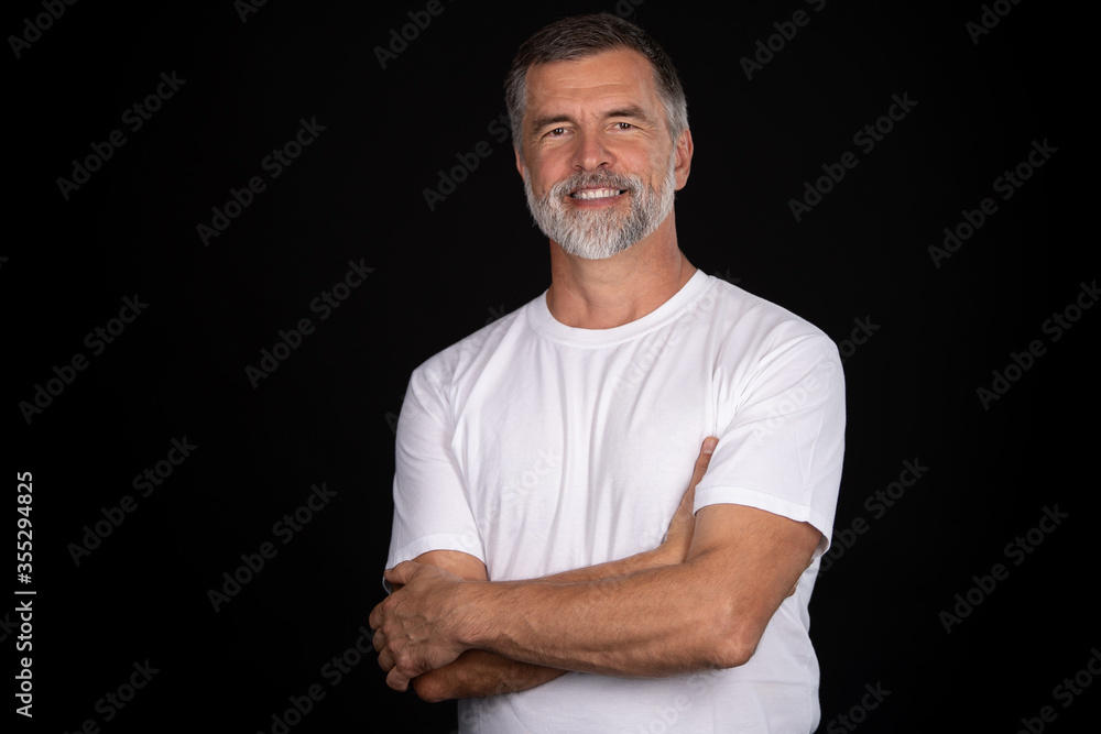 Portrait of smiling mature man standing on black background. Portrait of smiling mature man standing on black background.