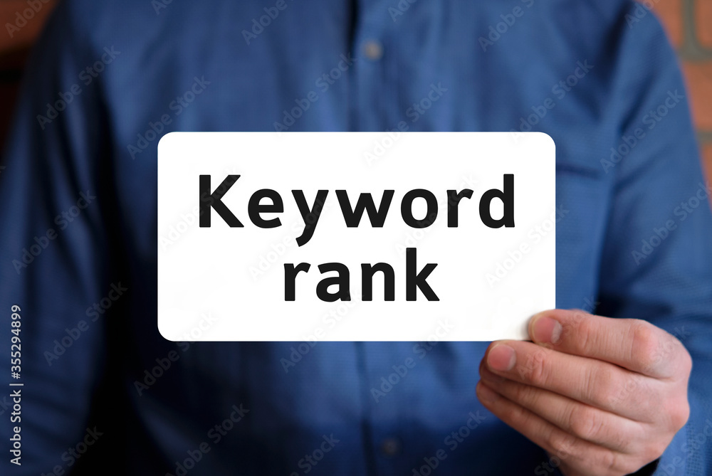 Keywords rank - text on a white sign in the hand of a man in a blue shirt Keywords rank - text on a white sign in the hand of a man in a blue shirt