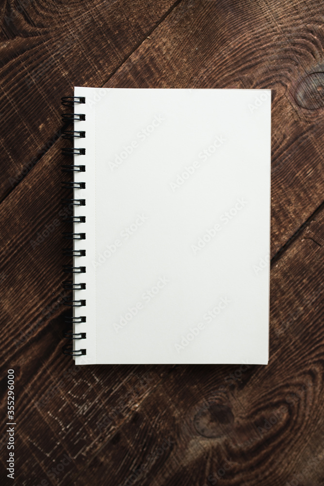 Top view image of an open notebook with blank pages on a wooden table. Ready to add text or layout. Space for text or image. Top view image of an open notebook with blank pages on a wooden table. Ready to add text or layout. Space for text or image.