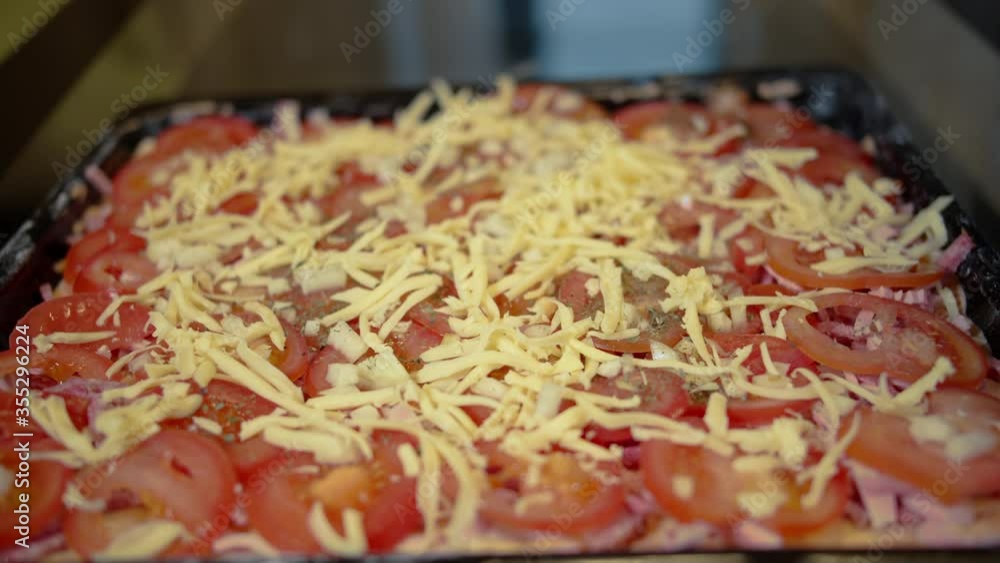 Man cook pizza at home, sprinkle with cheese, homemade food Man cook pizza at home, sprinkle with cheese, homemade food
