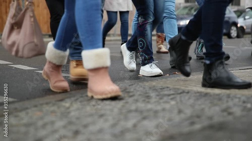 Lots of Peoplees walking on the sidewalk. CLose Up