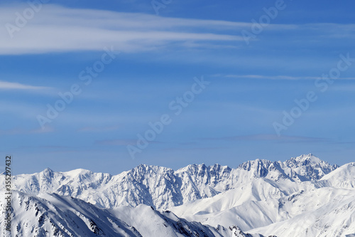High snowy mountains and blue sky with clouds © BSANI