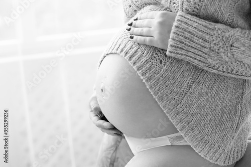 беременность. беременная девушка живот крупным планом. рука на беременном животе. беременность черно-белое фото