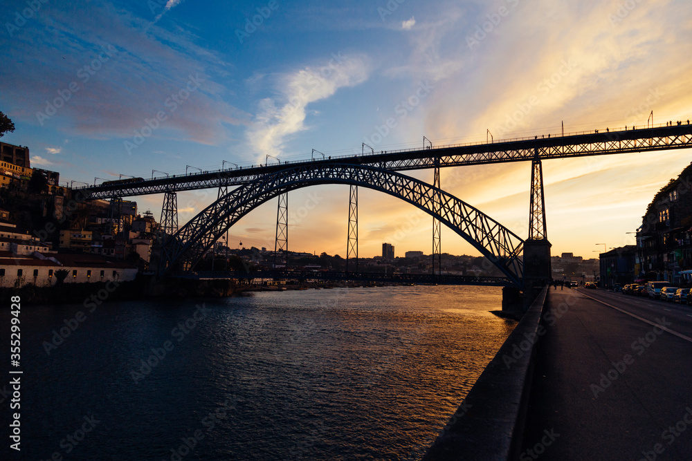 Porto, Portugal, cityscape on the Douro River with Luis I bridge at sunset with beautiful sky and reflex on the water.