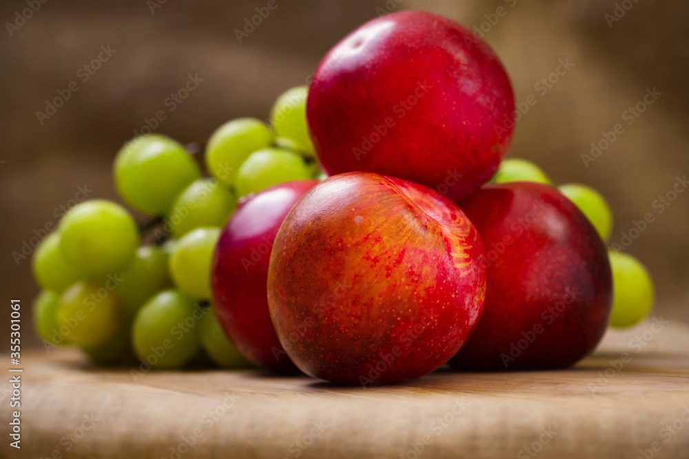 Fresh white grapes and nectarine on a wooden board, Hessian backdrop. Still life. Fresh white grapes and nectarine on a wooden board, Hessian backdrop. Still life.