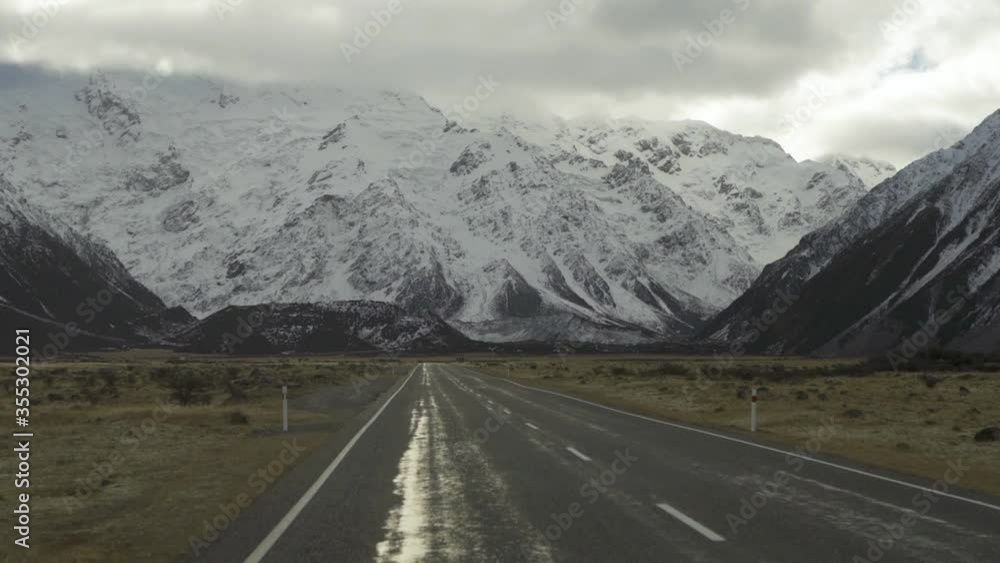 Driving through the valley in New Zealand with beautiful snowy mountain view ahead (slow motion 120fps) Driving through the valley in New Zealand with beautiful snowy mountain view ahead (slow motion 120fps)