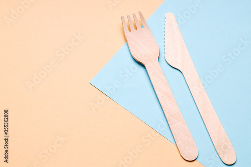 eco-friendly disposable utensils concept. bamboo or wooden cutlery over color background.