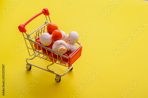 tomato and mushrooms in a basket on a yellow background
