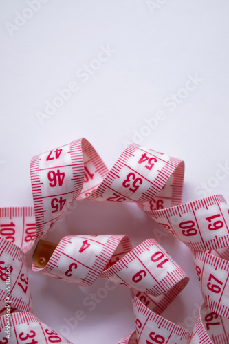 Close up of Red measuring tape on white background. Loss weight concept. Top view. Copy space. Isolated. High quality photo
