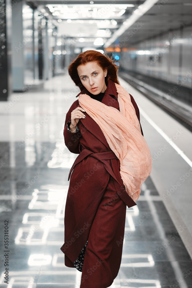 Red-haired girl in the subway, red coat