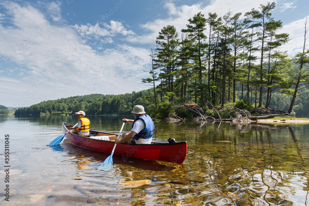 father and son canoeing in a lake 