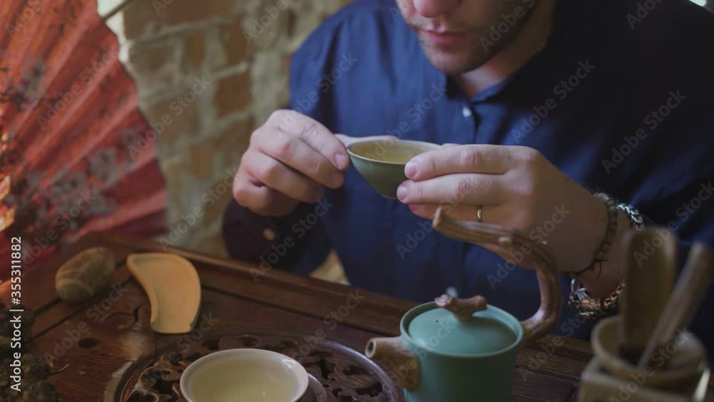 Close Up of Man is drinking green tea from Gaiwan Close Up of Man is drinking green tea from Gaiwan