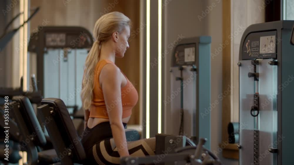 Beautiful fit woman training at gym. Sport woman making leg press in sport club Beautiful fit woman training at gym. Sport woman making leg press in sport club