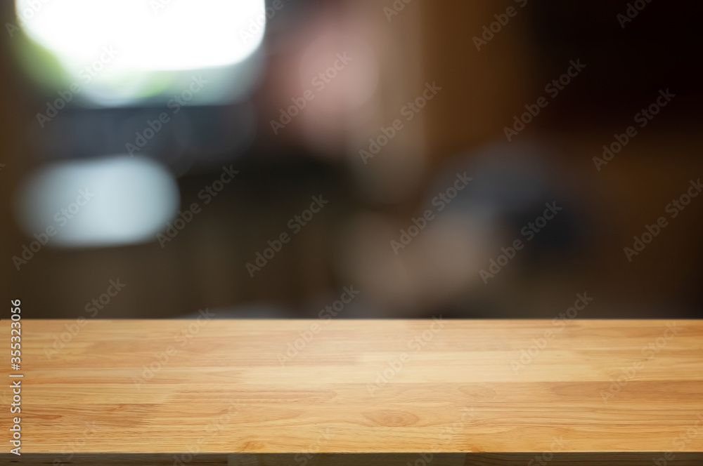 Wooden top table with blurred montage coffee shop cafe background.