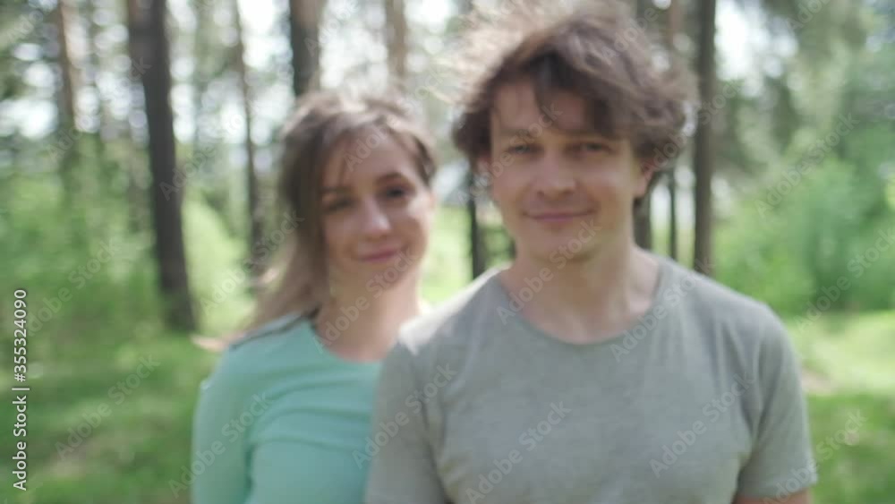 Portrait of the young couple standing outdoor in the sunny forest Portrait of the young couple standing outdoor in the sunny forest
