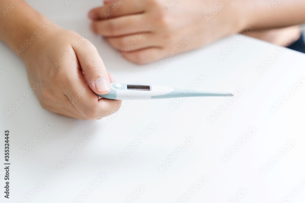 close up of woman checking thermometer and measure body temperature. close up of woman checking thermometer and measure body temperature.