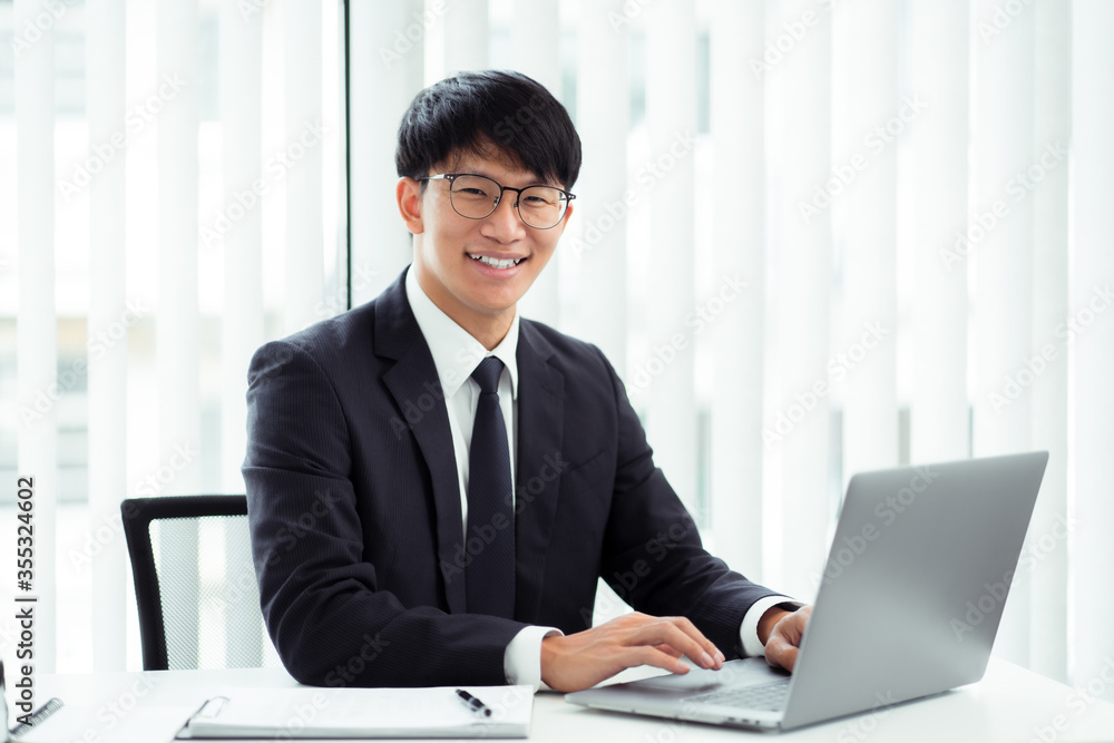 Attractive asian smiling businessman in office place, Confident young man. Attractive asian smiling businessman in office place, Confident young man.