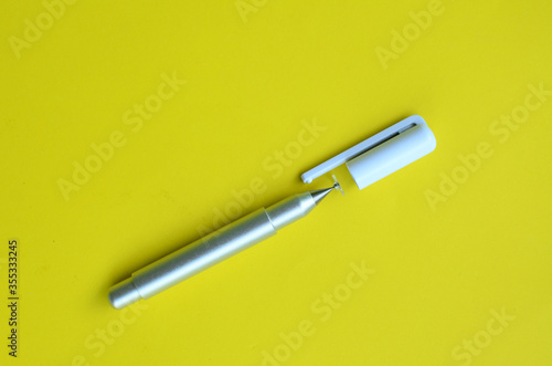 top view of the stylus pen on yellow background 