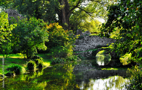 Fototapeta Naklejka Na Ścianę i Meble -  Garden of Ninfa: detail of stone bridge on the river.