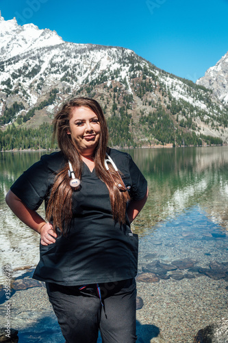 Woman nurse in black scrubs with a stethoscope in the mountains