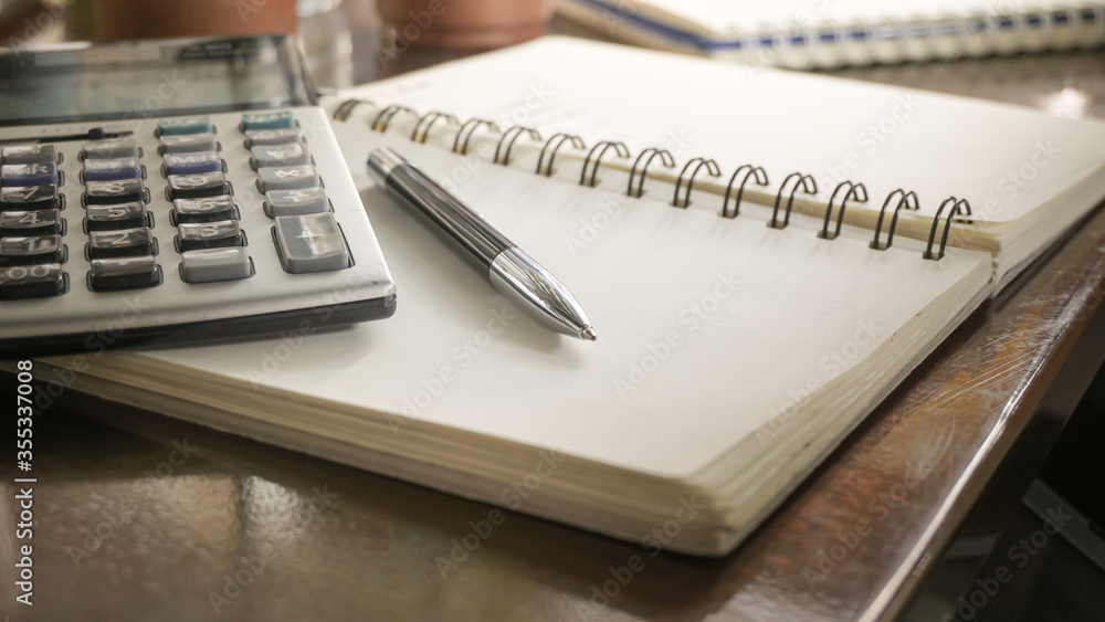 a Pen on a notebook with a Calculator a Pen on a notebook with a Calculator