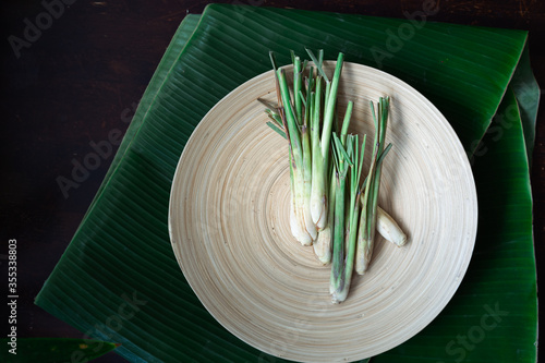 Fresh Lemongrass (Cymbopogon citratus) or citronella, serai on a wooden plate.