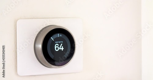 A person using a smart phone application saving energy with a wireless smart thermostat on a white background.