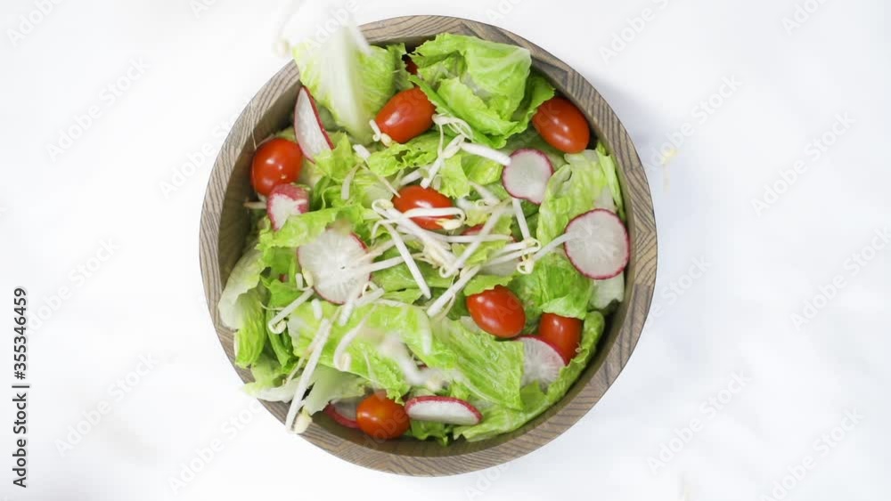 Sprouts falling into salad bowl from a top-down perspective Sprouts falling into salad bowl from a top-down perspective