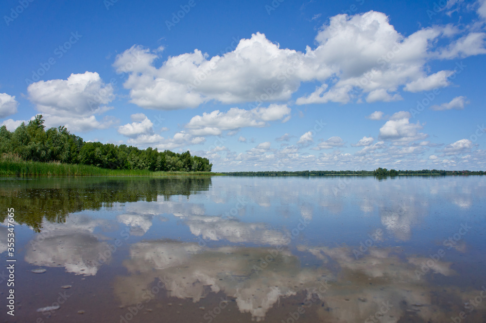 Obraz premium Landscape with a river and beautiful blue sky and white clouds. Ukraine, the Dnieper River.