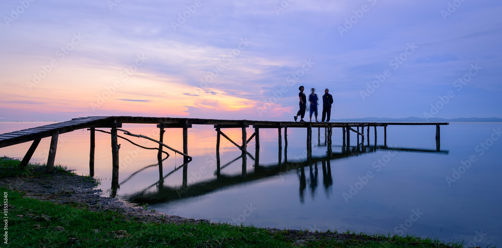 people walk on the bridge over the sea in the morning